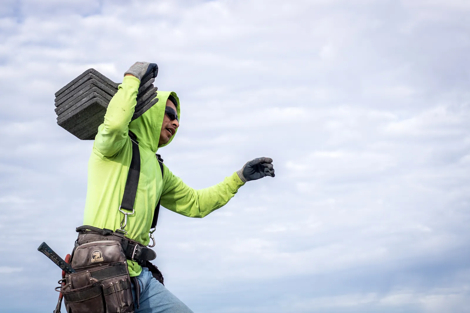 Elite roofer carrying roof tiles for a storm damage roof restoration in Arizona